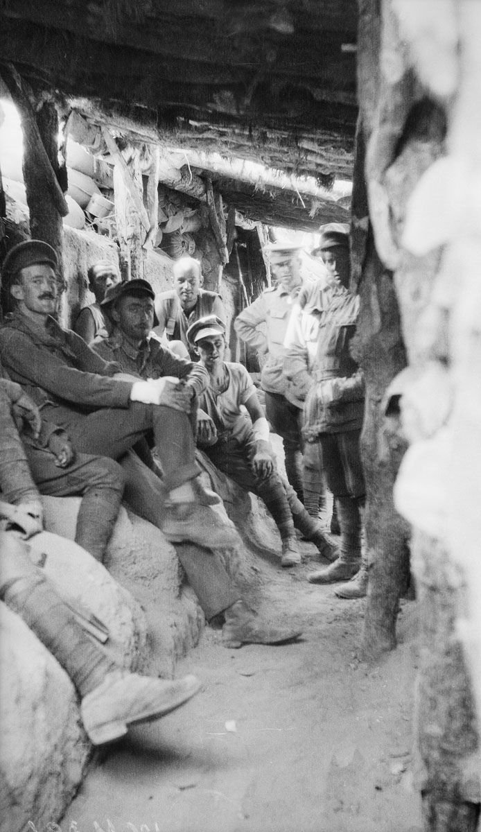 Australian troops relax inside a captured Turkish trench at Lone Pine. The headcover of this trench has been broken through by shelling.